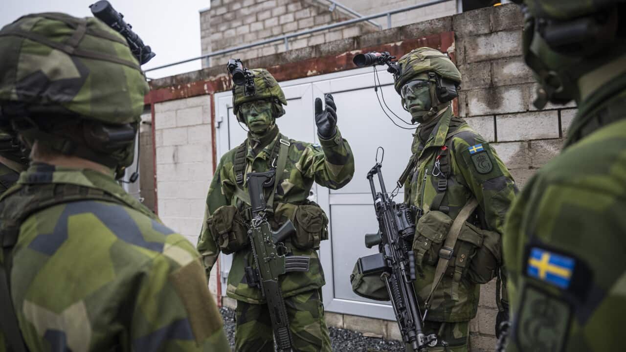People wearing combat gear are speaking.