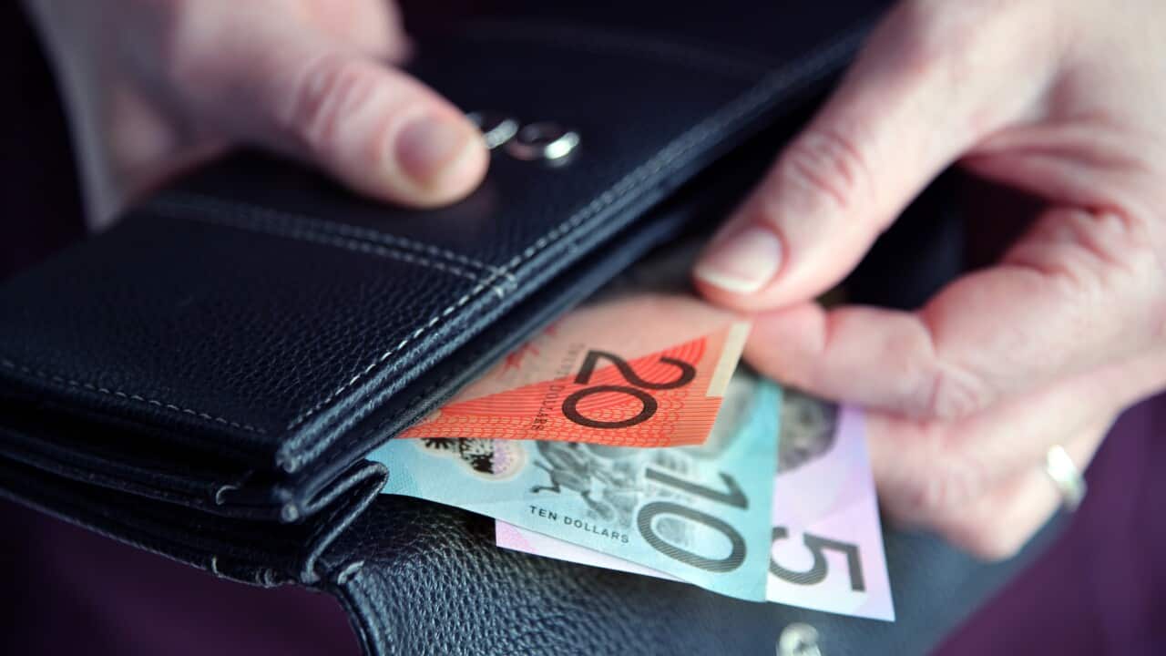 A woman taking money from her wallet.