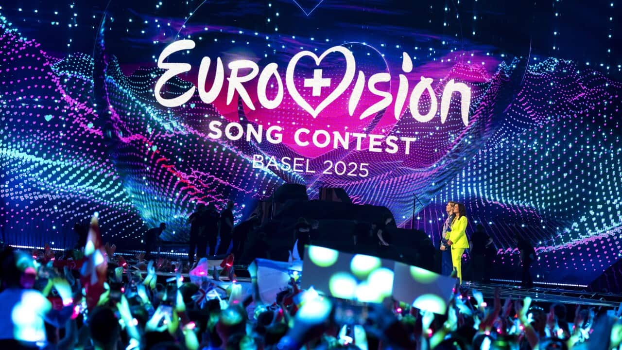 A crowd looking at a stage displaying a screen that says: Eurovision Song Contest Basel 2025