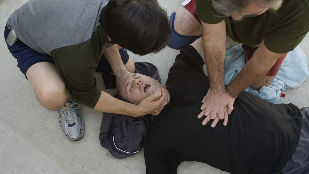 Men doing CPR on another man