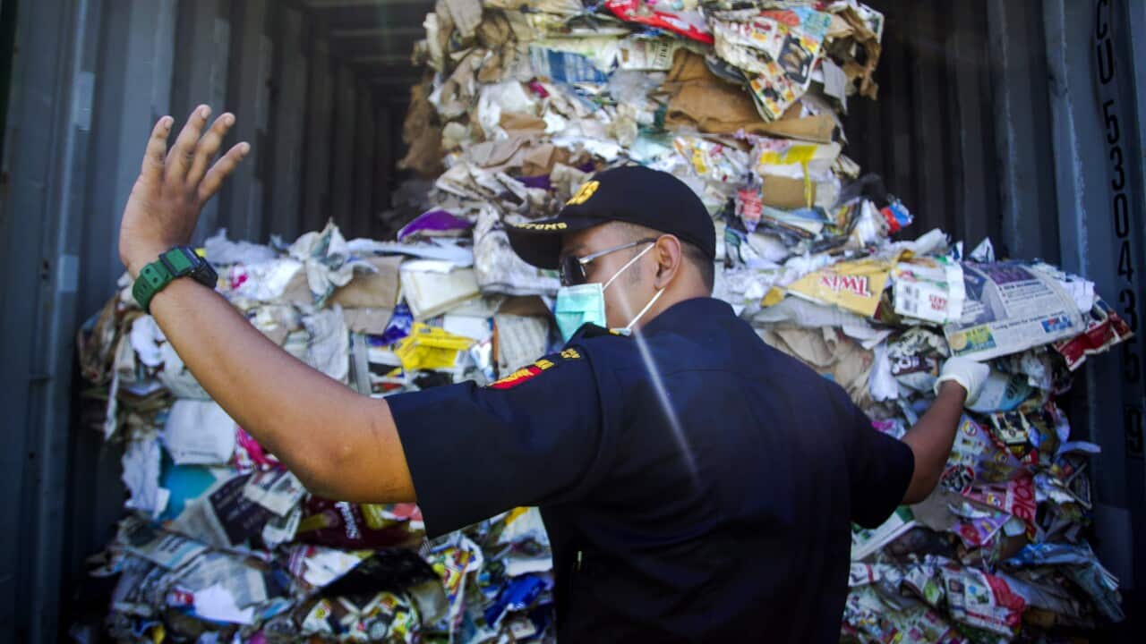 An Indonesian customs official inspects containers loaded with a combination of garbage, plastic waste and hazardous materials from Australia.