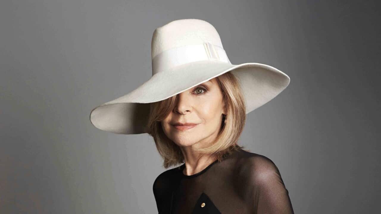 Fashion designer Carla Zampatti wearing a black dress and white hat.