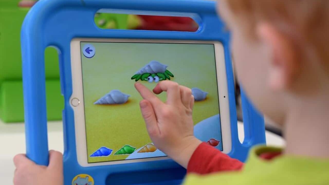 A file image of a boy playing on an iPad