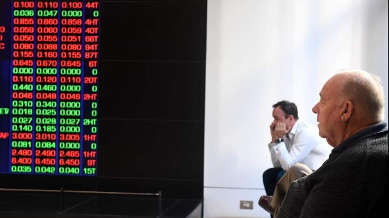 two men sitting watch ASX information board