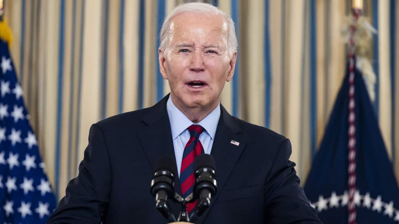 A man speaking while standing at a lectern.