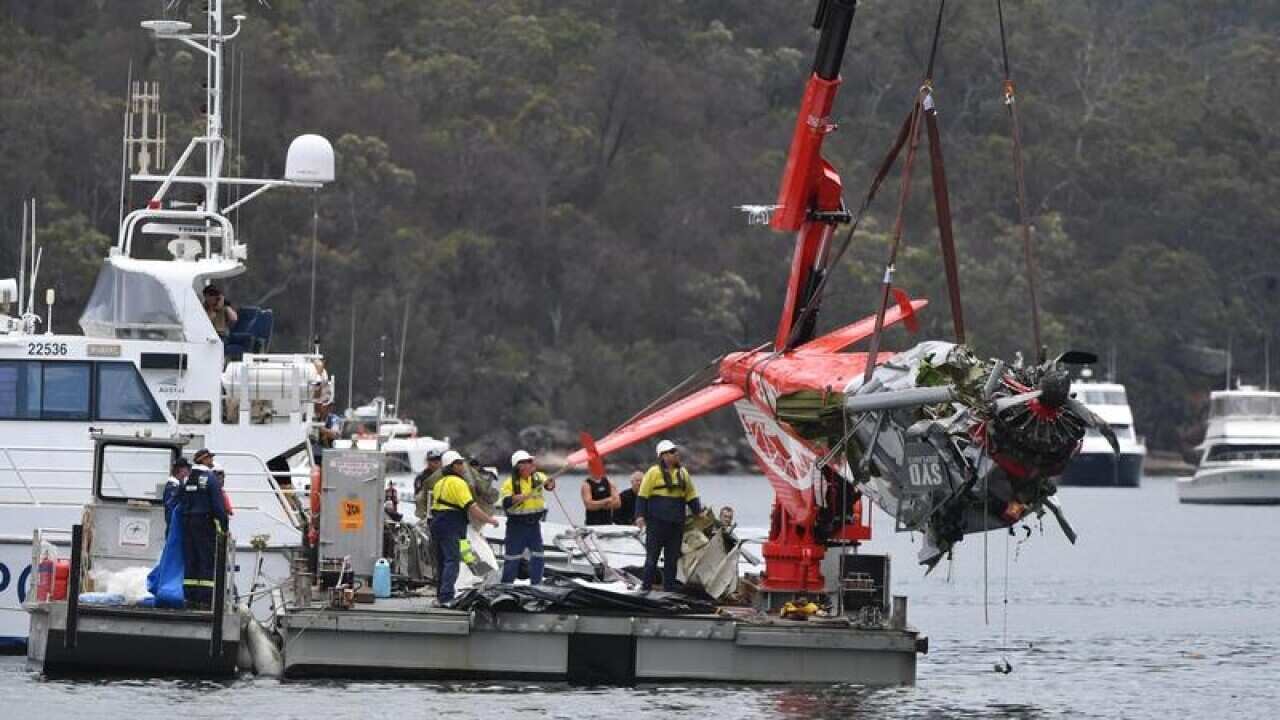 NSW police and salvage personnel recover the wreckage of a seaplane.