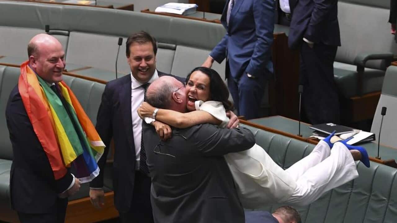 Liberal MP Warren Entsch lifts up Labor MP Linda Burney celebrate.