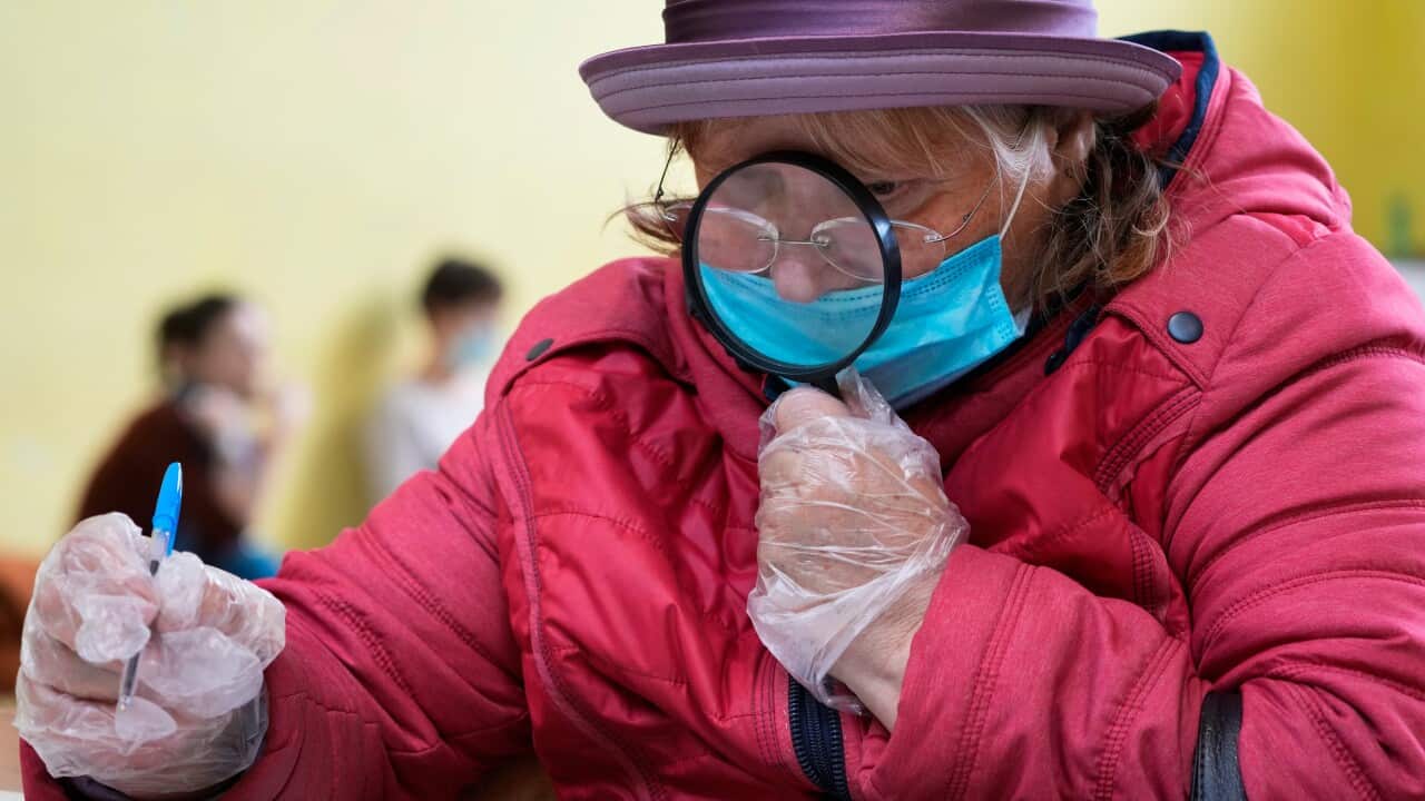 A woman fills her ballot paper during the State Duma