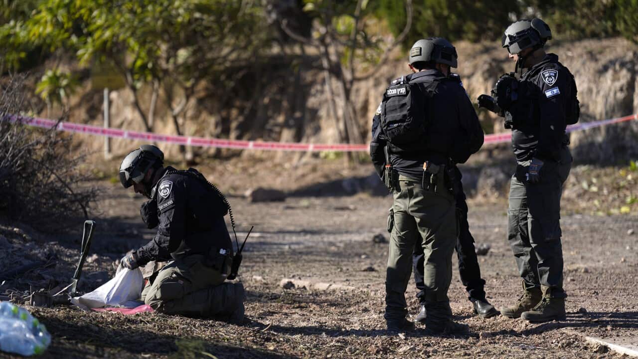 Israeli police explosive ordnance disposal specialists work at a site.