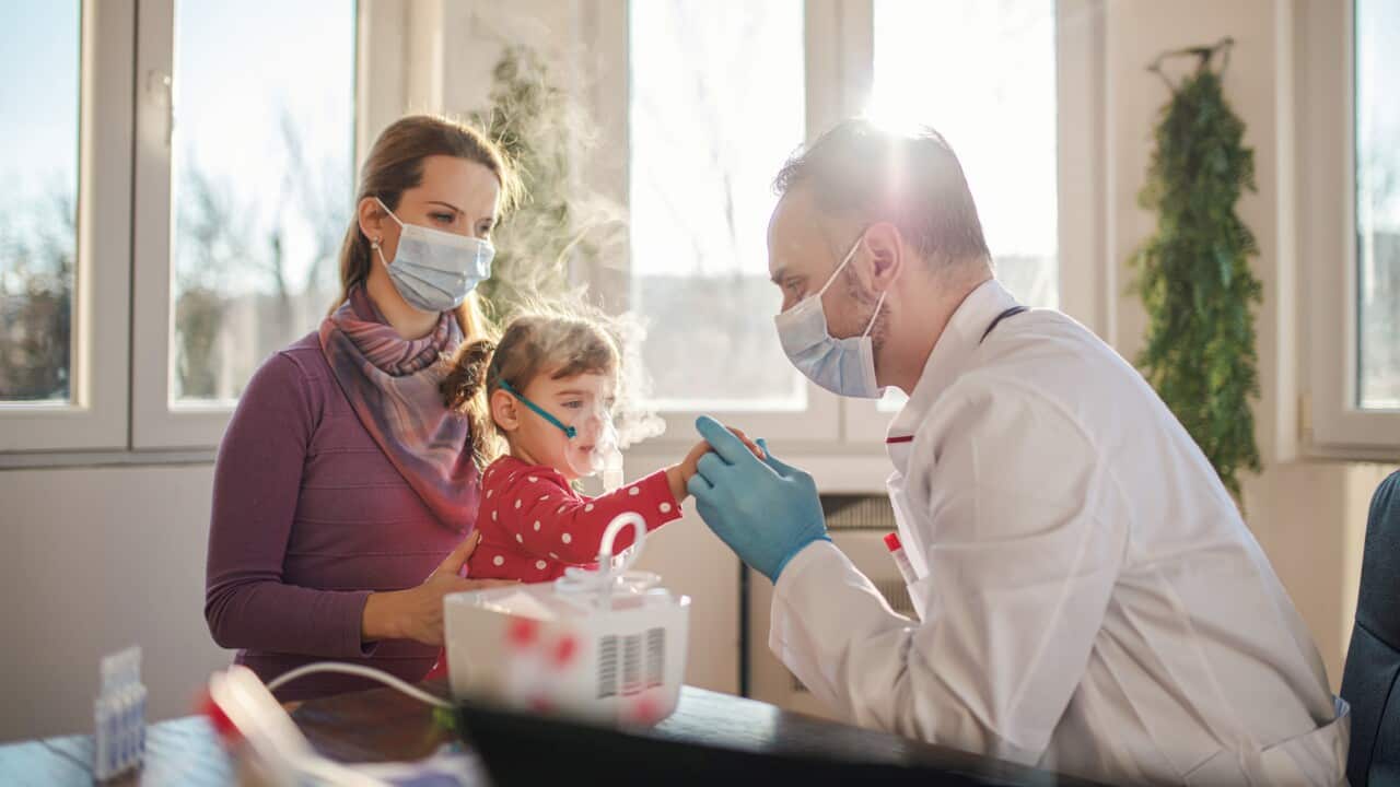 Medical doctor applying medicine inhalation treatment on a little baby girl
