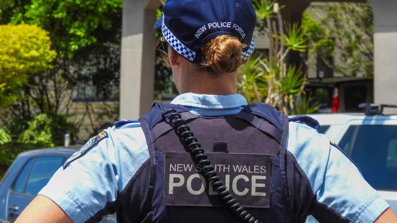 A female NSW Police officer is with her back towards the camera.