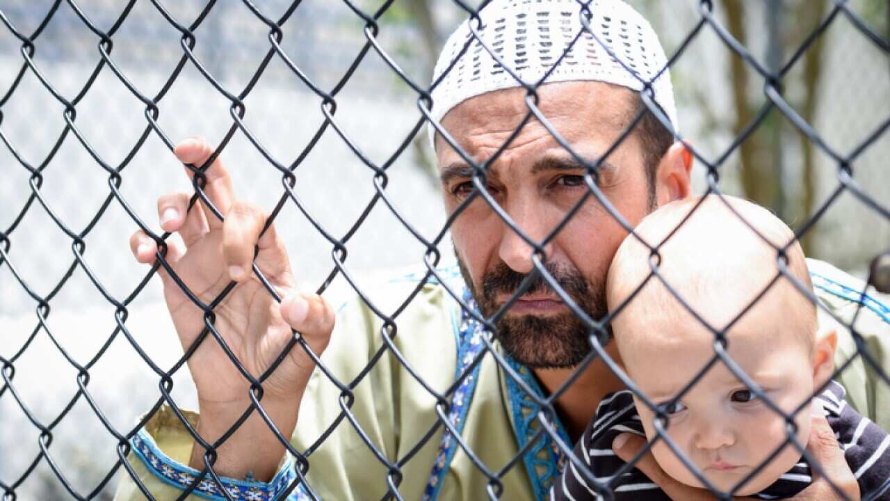 Muslim refugee holding his baby