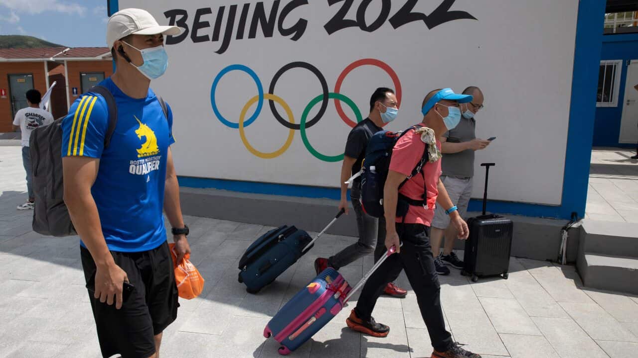 Visitors walk past by the Winter Olympics Beijing 2022 logo in Chongli, in northern China's Hebei Province.