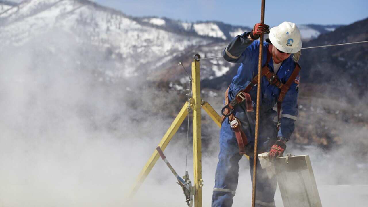 A worker checks water levels at a gas drilling site in Colorado