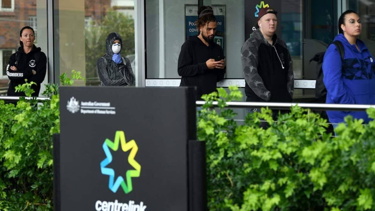 People are seen queuing outside a Centrelink office in Bondi Junction, Sydney, Tuesday, March 24, 2020.