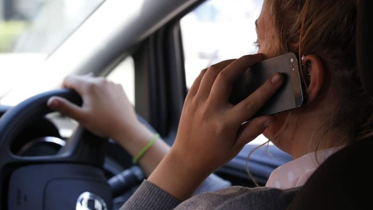 Woman using a mobile phone while driving.