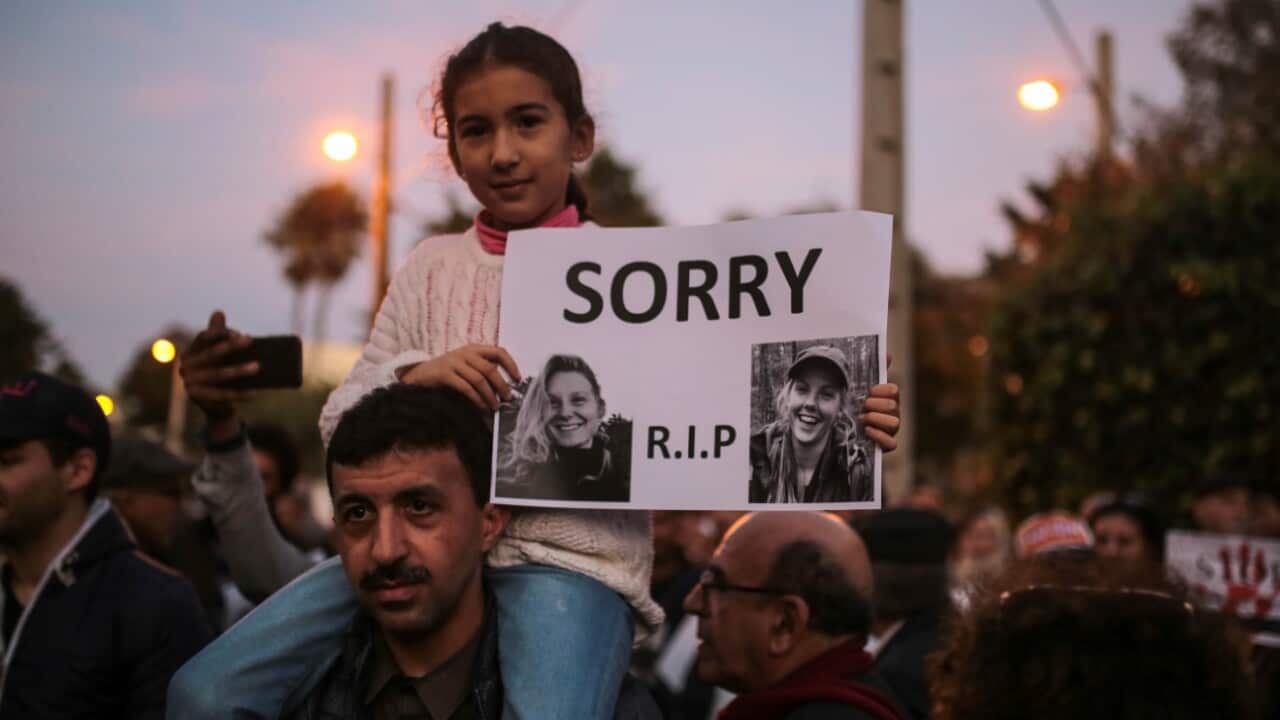 A girl carries the picture of 28-year-old Norwegian Maren Ueland and 24-year-old Danish Louisa Vesterager Jespersen, during a candlelight vigil
