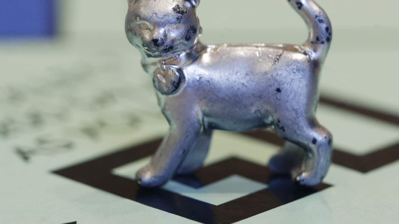A Monopoly board and token of a cat.