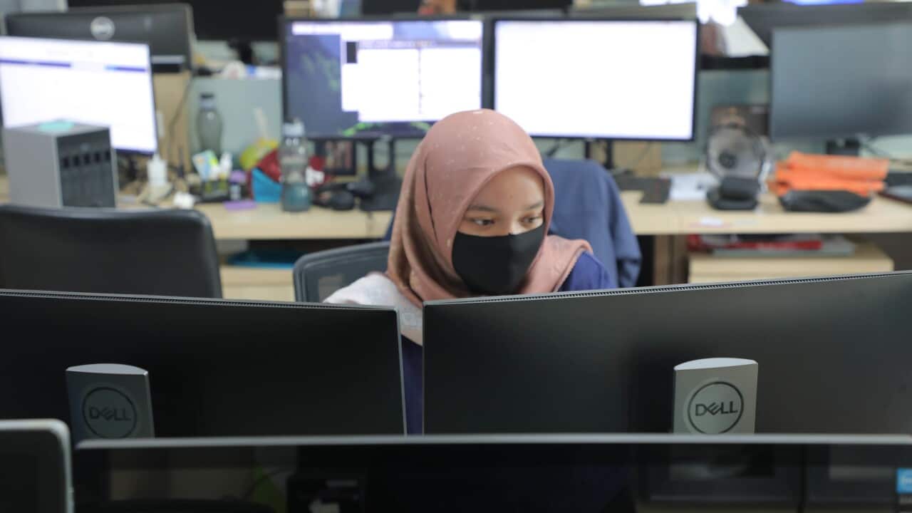 A worker wears a face mask in the office (AAP)