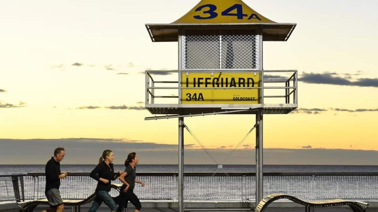 A file image of runners near a lifeguard tower on the Gold Coast.