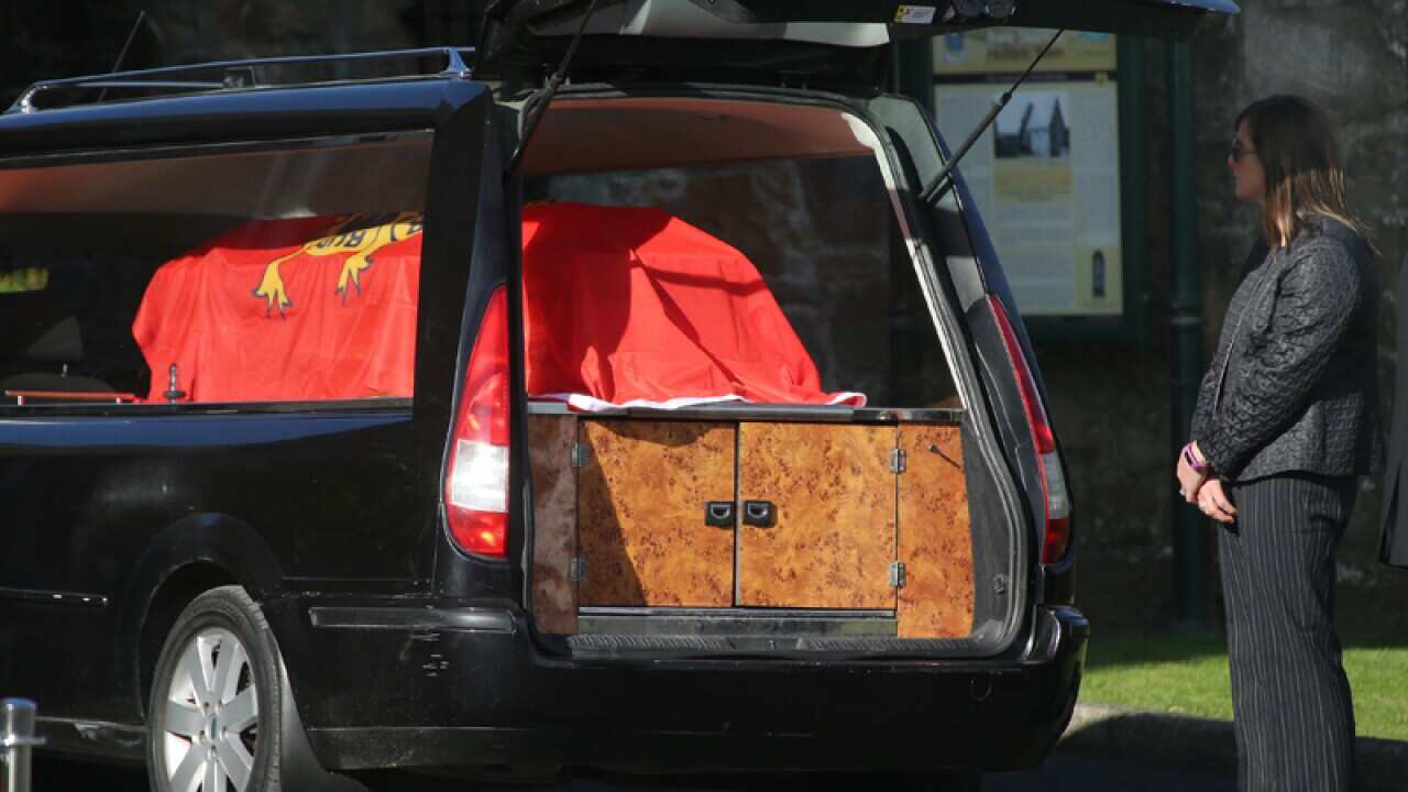 Anthony Foley's wife Olive looks at the coffin of her husband