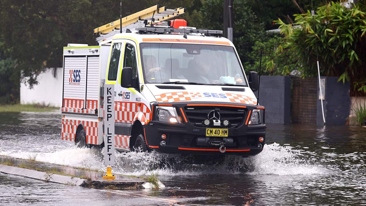An SES vehicle drives through flooded waters