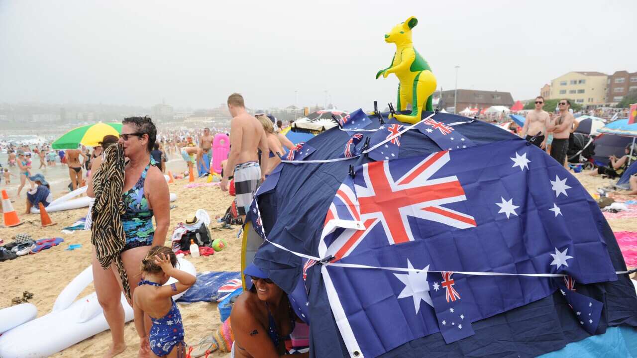 A beach goer show her Australian pride by covering herself in an Australian flag, tattoos and shirt on Australia Day at Bondi Beach in Sydney.