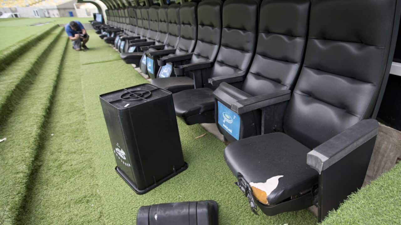 A trash can lays by ripped seats in Maracana stadium