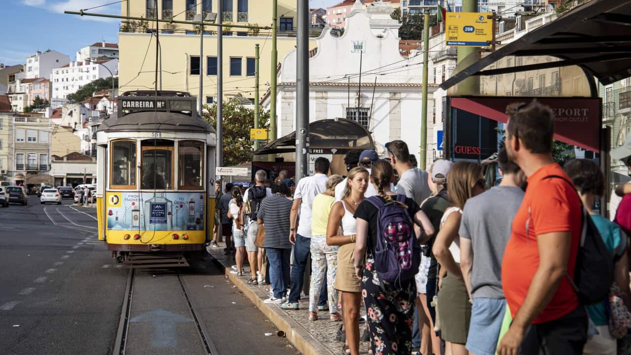 Tourists wait to board a tram in Lisbon