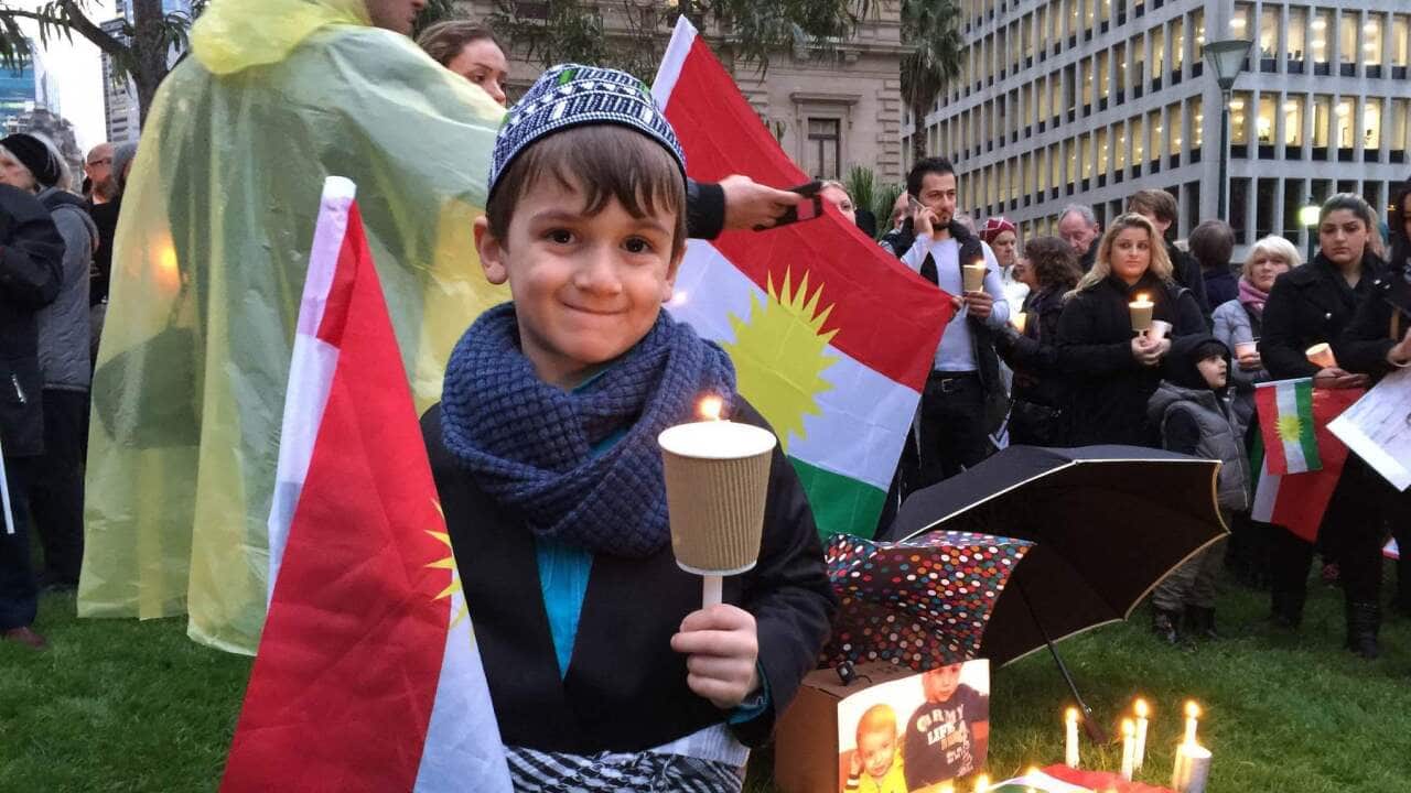 : A 5-year-old boy attends a refugee vigil in Melbourne (