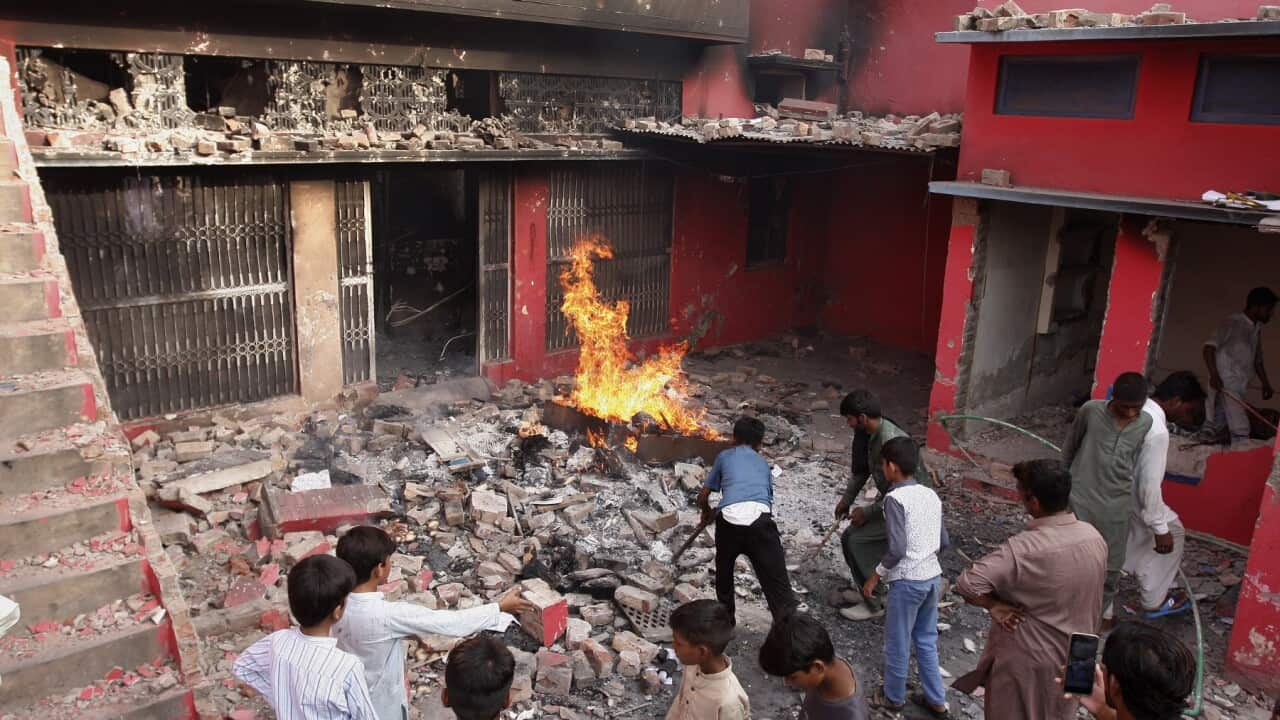 Youngsters look at a church damaged and burned by an angry Muslim mob near Faisalabad, Pakistan