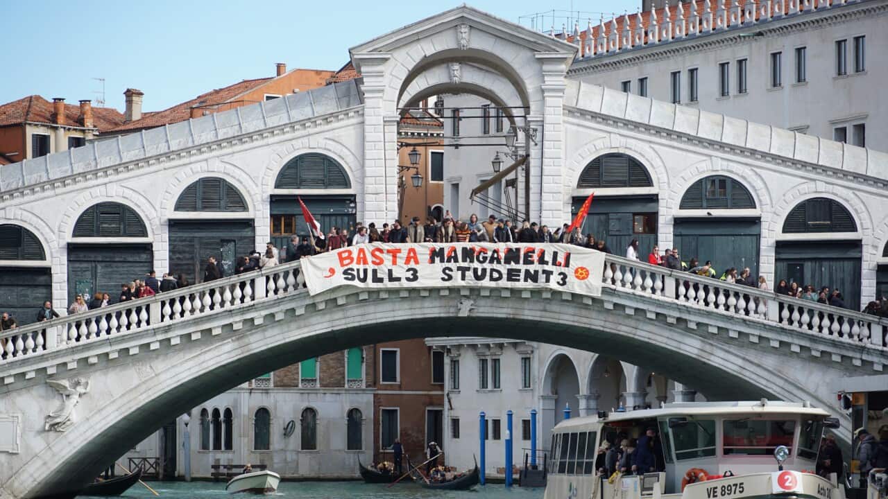 Some students lower a banner from the Rialto bridge onto the Grand Canal with a slogan protesting against police charges against a procession of students during a pro-Palestine demonstration in Pisa in recent days, 25 February 2024.
