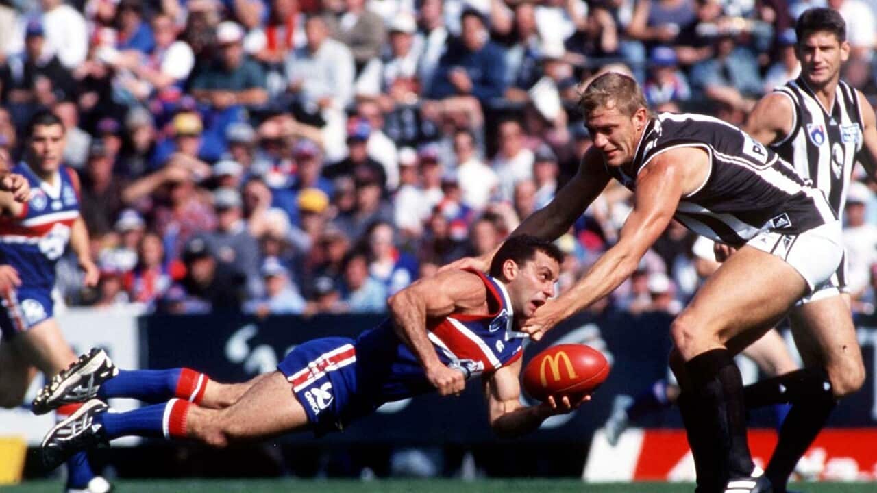 Tony Liberatore con la maglia dei Western Bulldogs si butta ad angelo durante una partita contro Collingwood, la sua 200esima in cariera.
