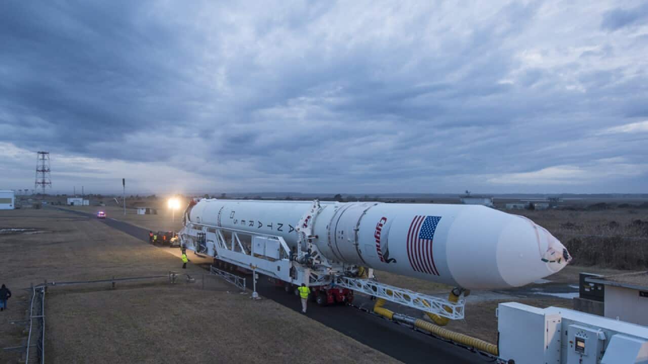 An Orbital Sciences Antares rocket is rolled out to a launch pad