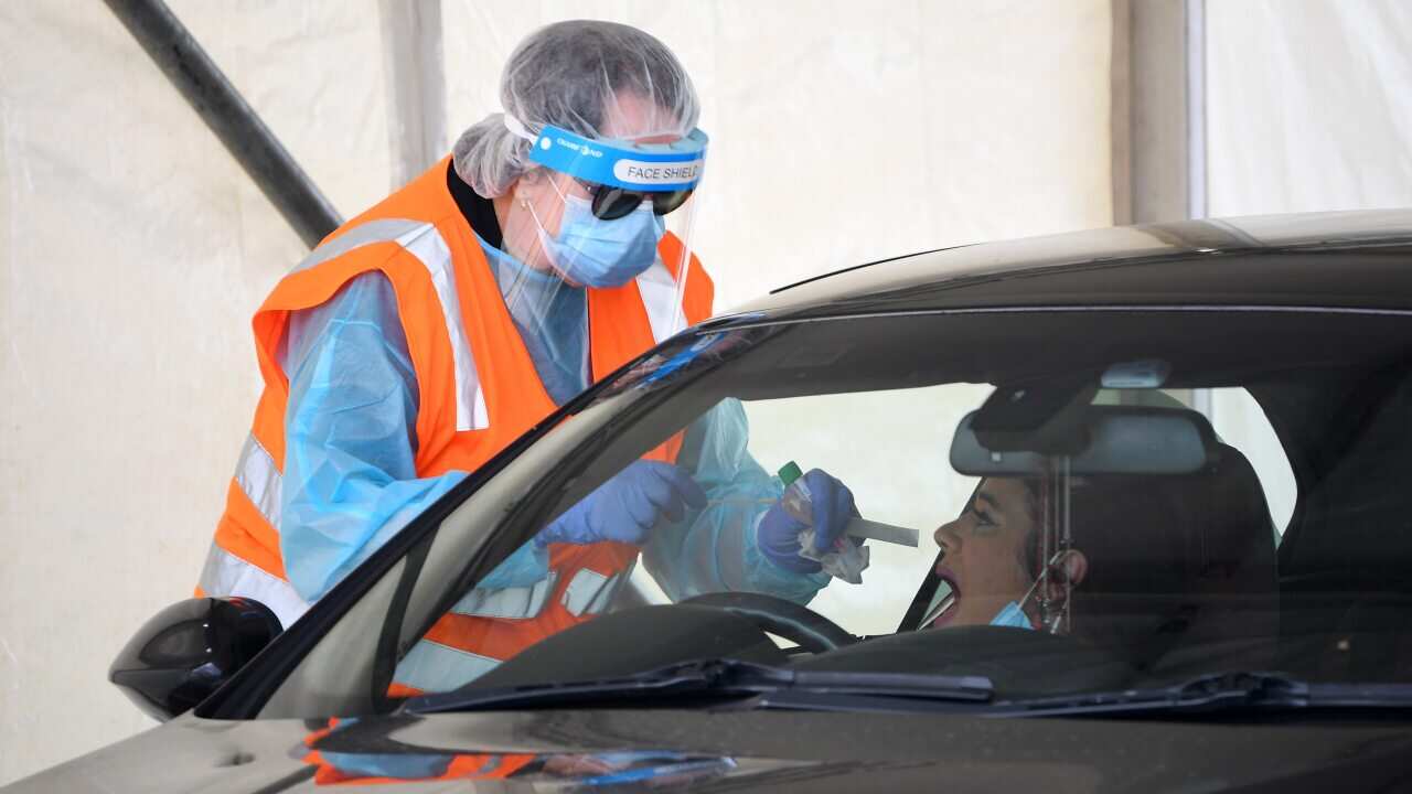 A healthcare worker conducts a coronavirus test at a drive-through COVID-19 testing facility in Shepparton, Victoria, Thursday, 15 October, 2020.