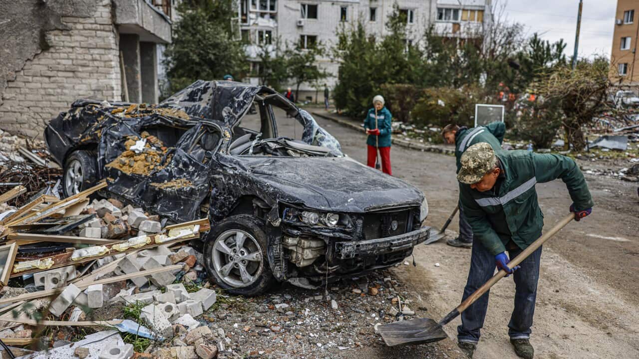 People clean up after a shelling in southern Ukraine
