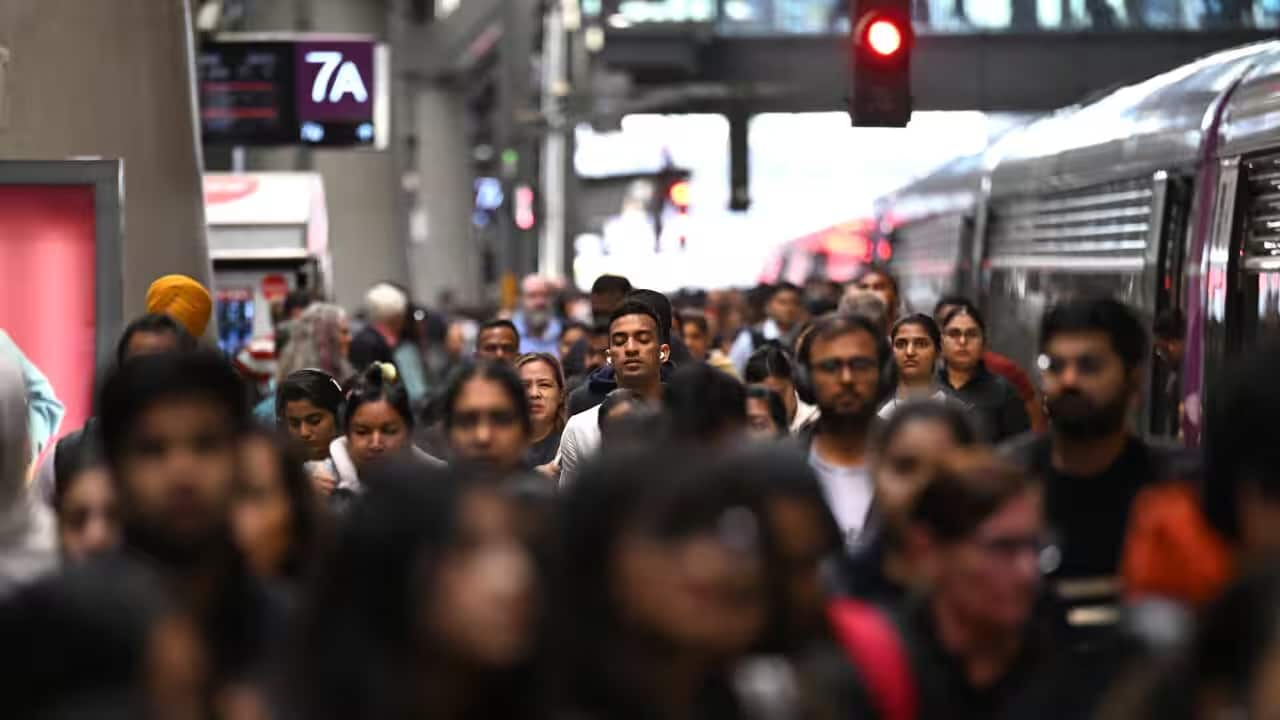 People walking along a busy train platform in a large city.png