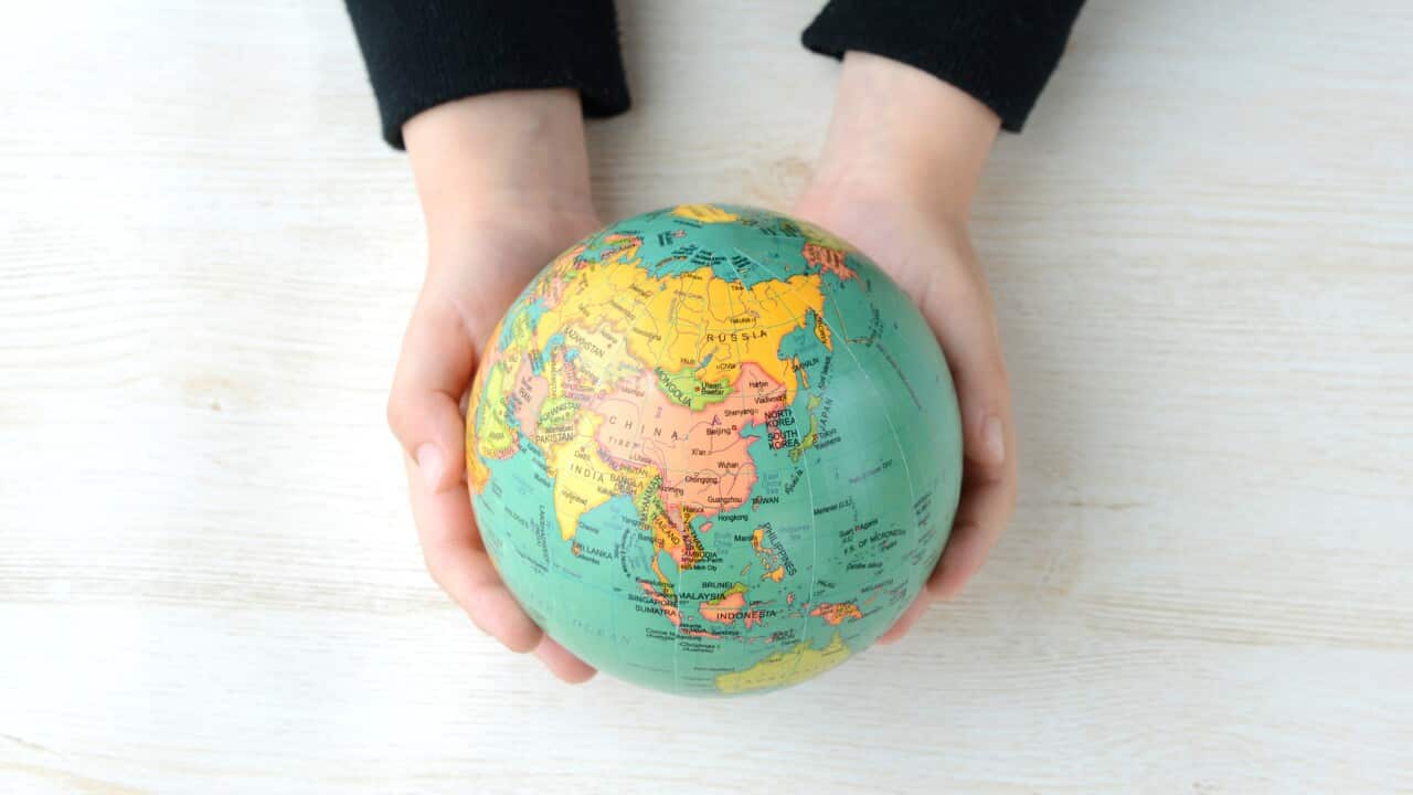 Child's hand having terrestrial globe