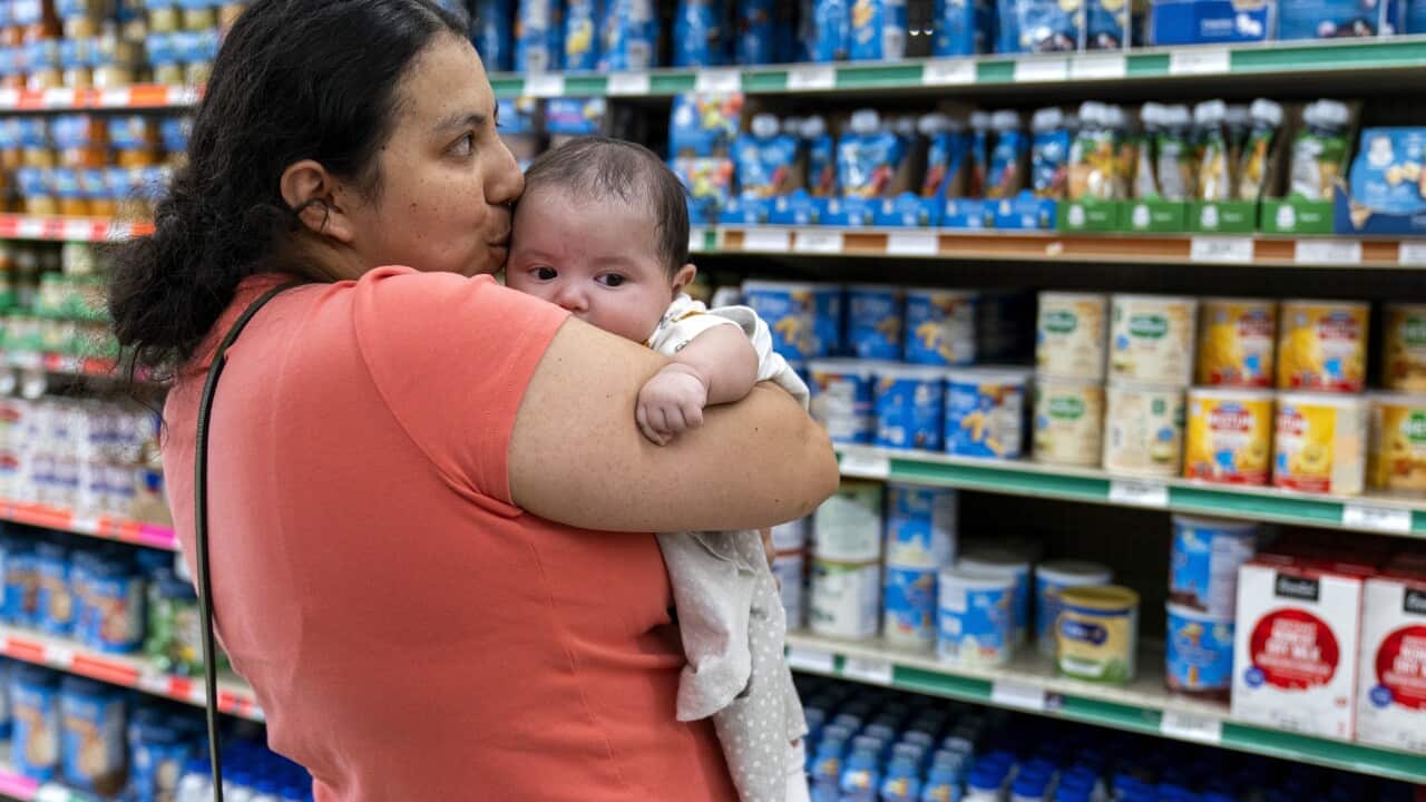 母親站在配方奶貨架前