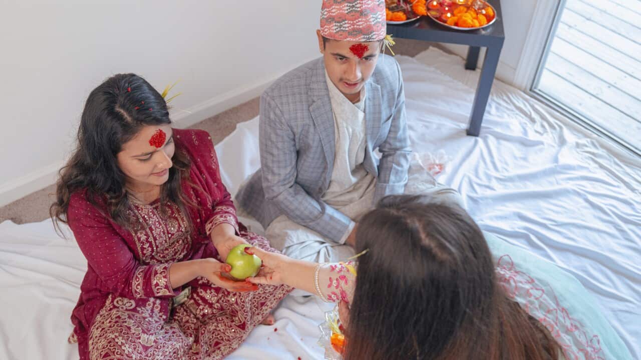 Happy Dashain - Nepal’s Most Important Holiday - Older Sister Gifting Younger Sister an Apple - Dashami - 10th Day of Dashain - Jamara on Ears - Dhakatopi Hat