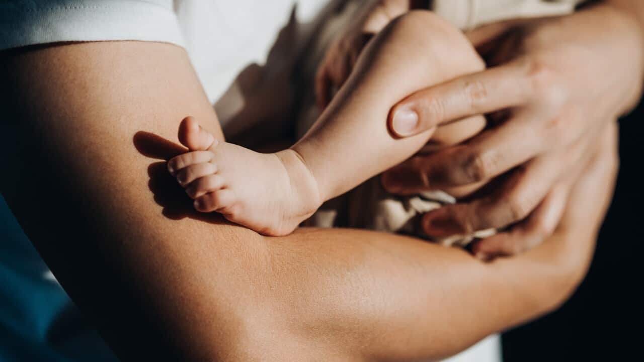 Close up of arms holding a baby