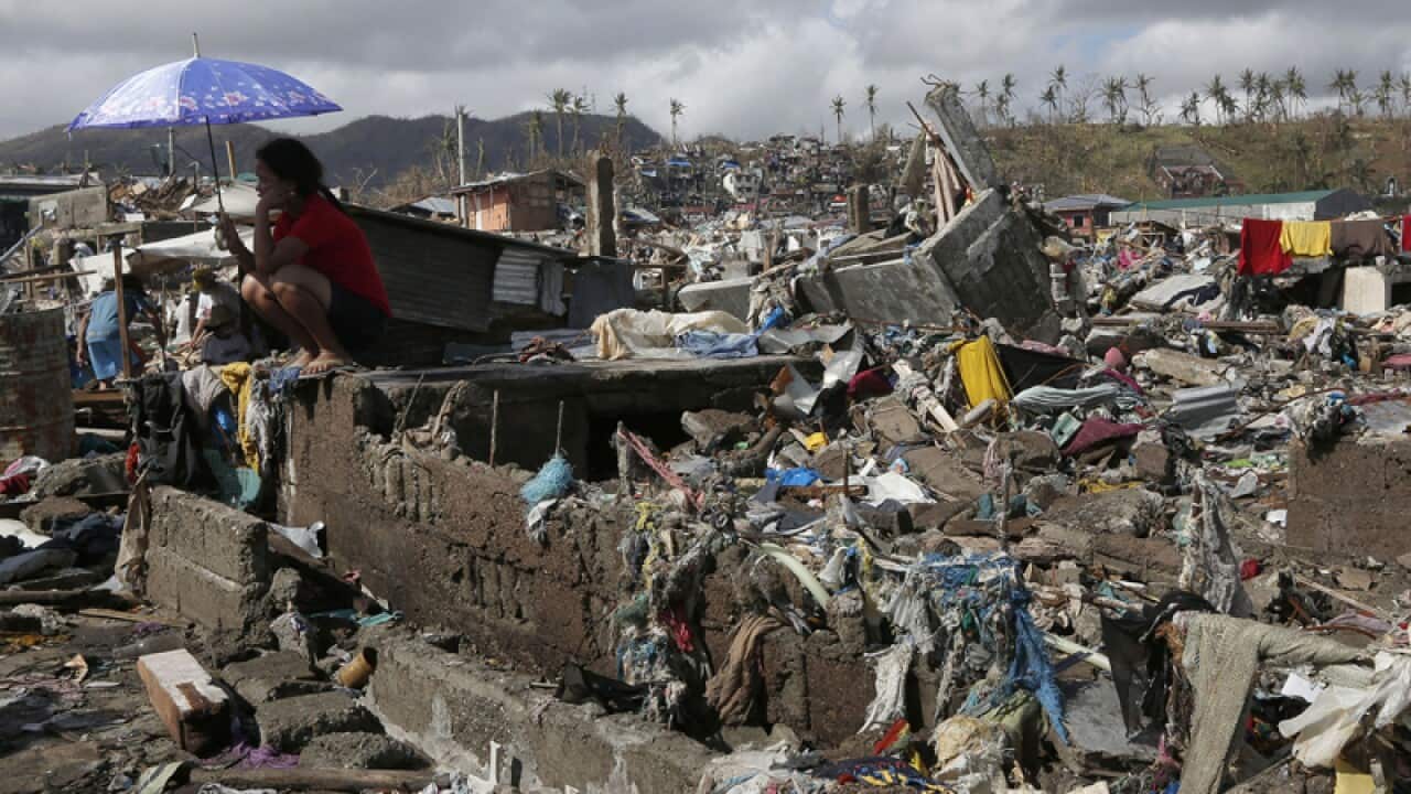 A survivor sits among debris in the typhoon-ravaged city of Tacloban