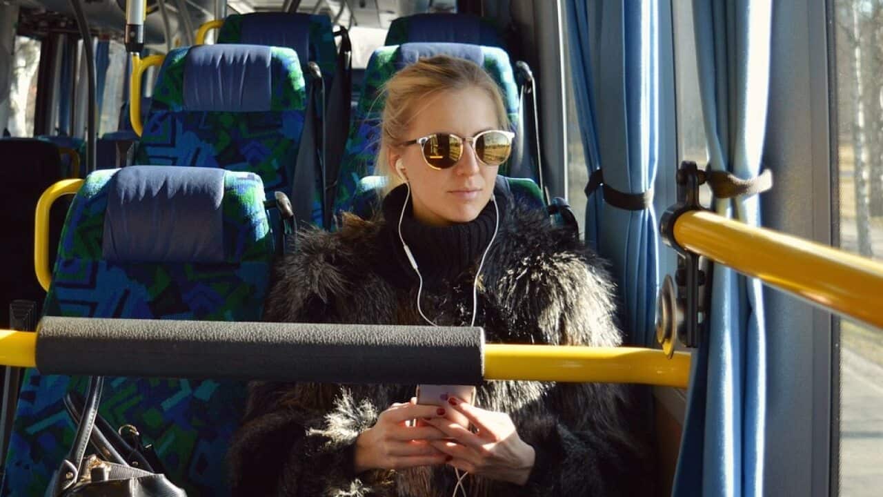Woman listening to smartphone on bus