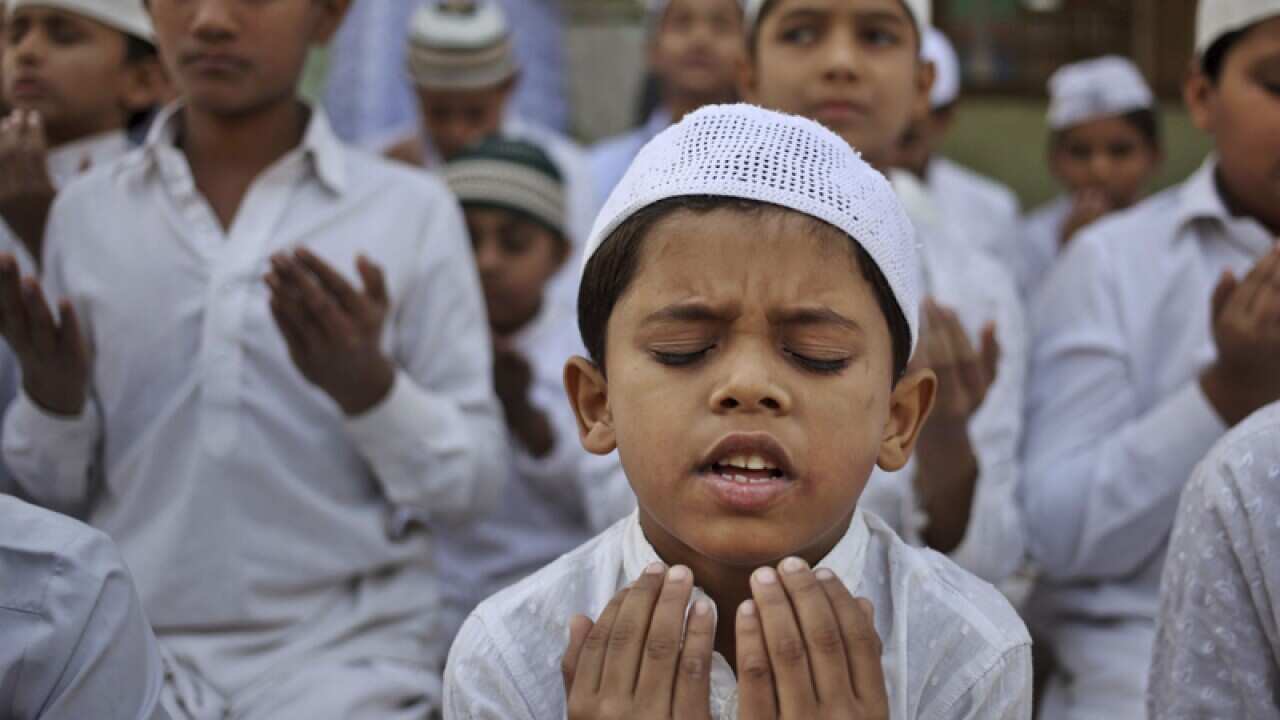 Indian Muslim children pray at a madrasa