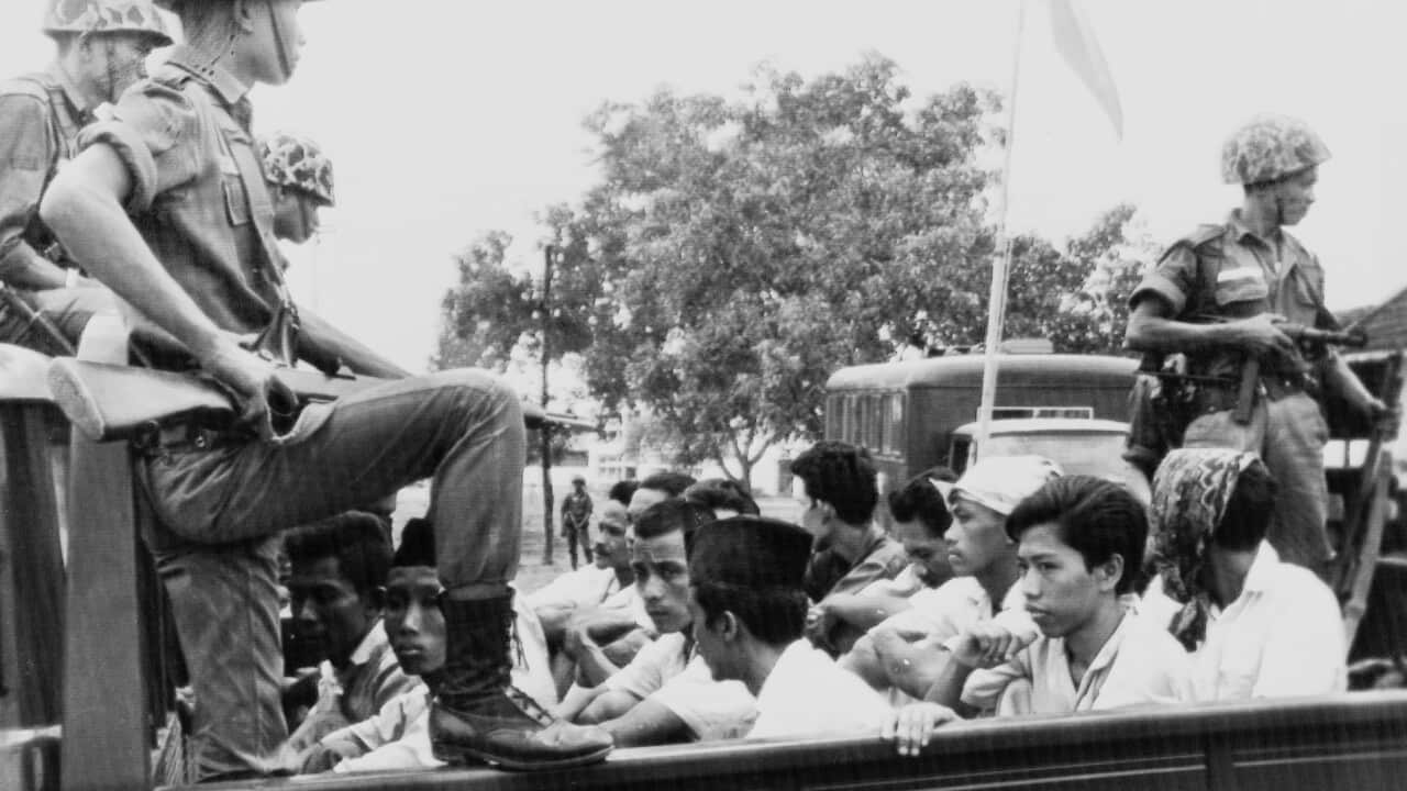 Members of the Youth Wing of the Indonesian Communist Party (Pemuda Rakjat) are guarded by soldiers