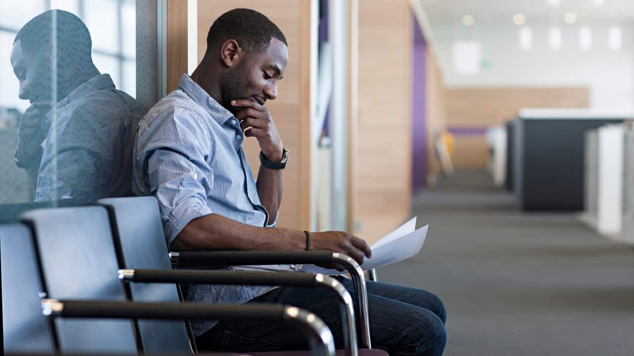 Man sitting on chair reading document