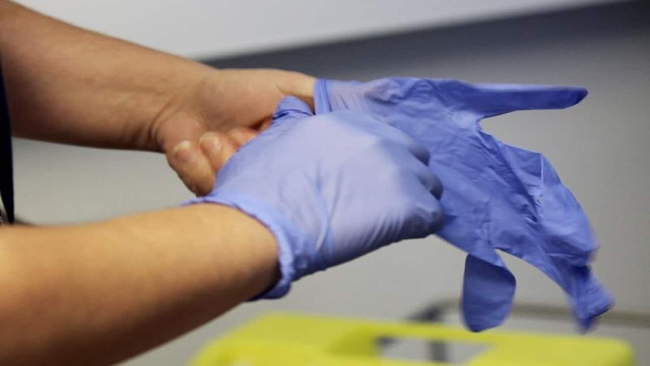 A man wearing latex gloves