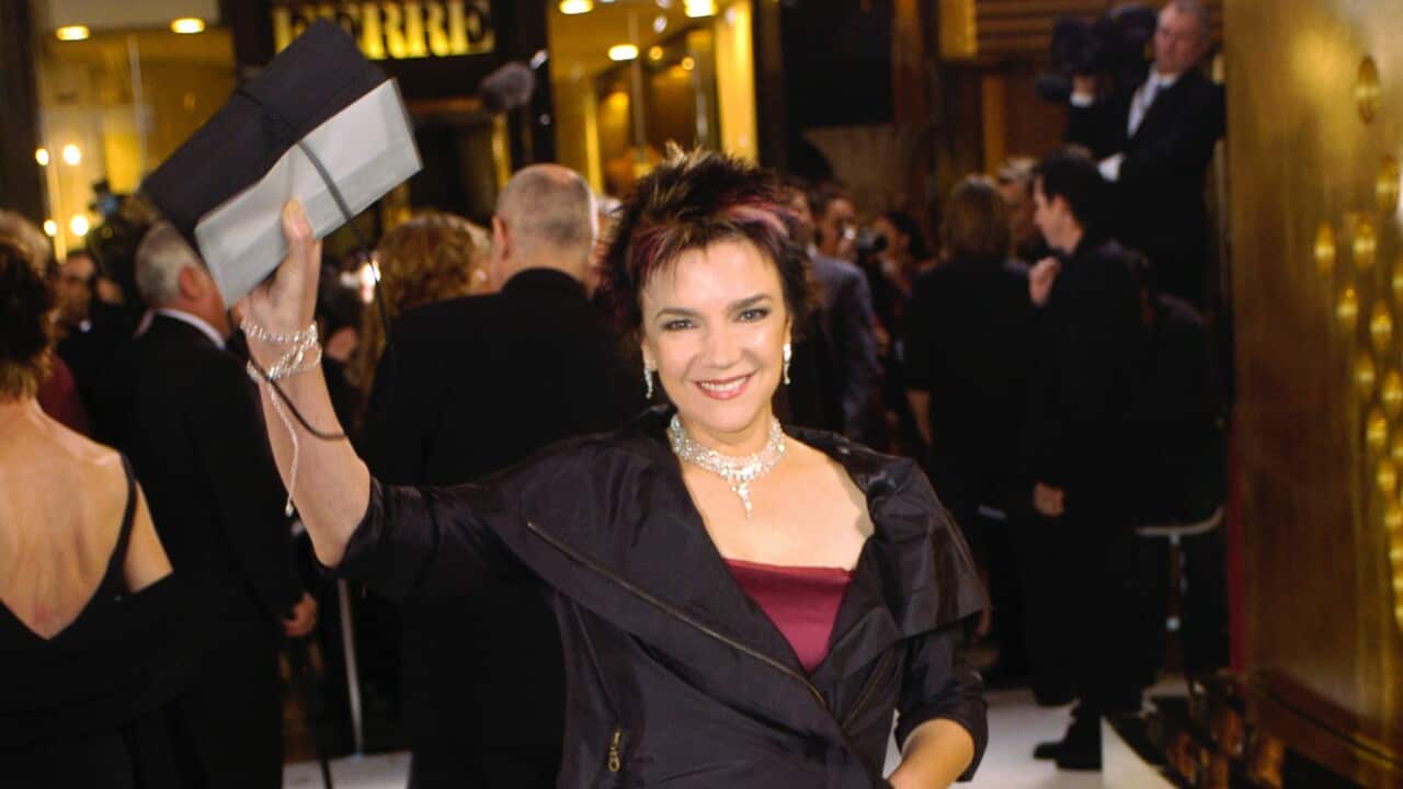 A woman holds up a clutch.