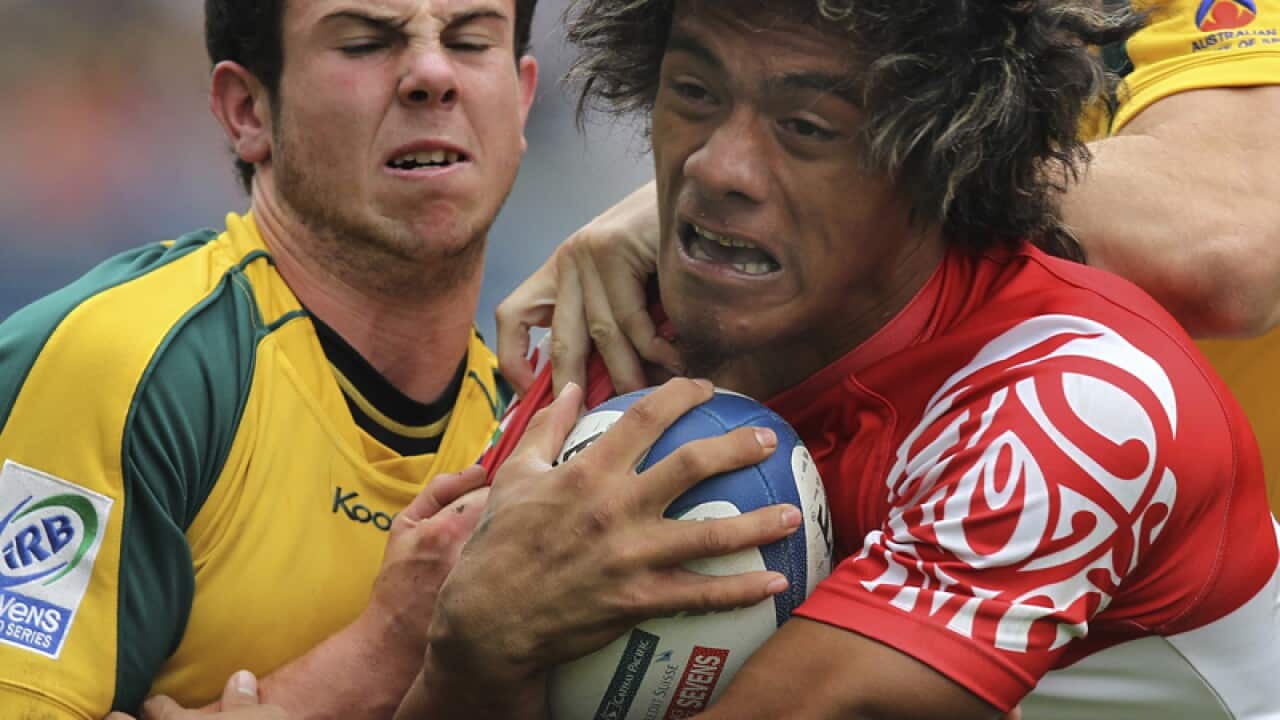 Australia's Robbie Coleman, left, charges Tonga's Siaosi Iongi, right