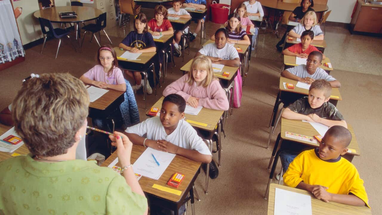 A teacher going over exam instructions with her class